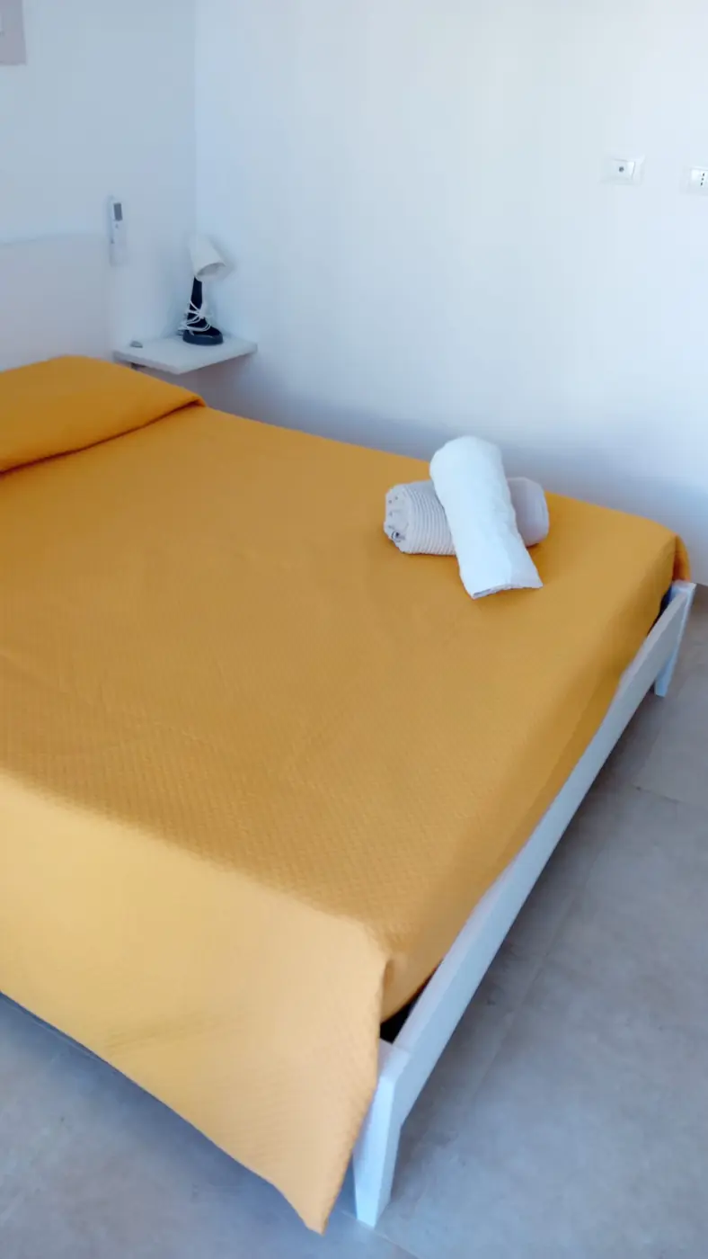 Casa di Mauro — camera matrimoniale con copriletto giallo